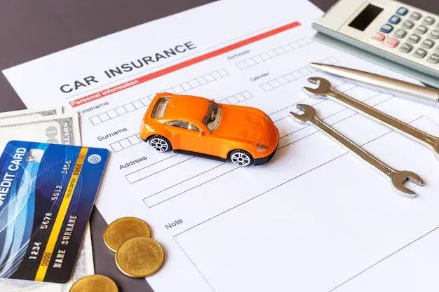 auto insurance form with small toy car on a desk.webp