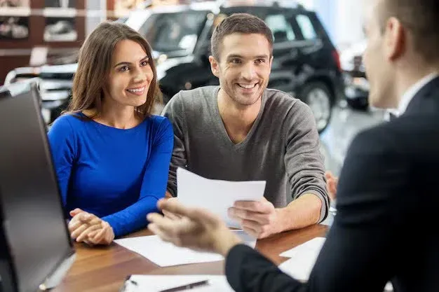 couple discussing auto insurance plans with broker.webp