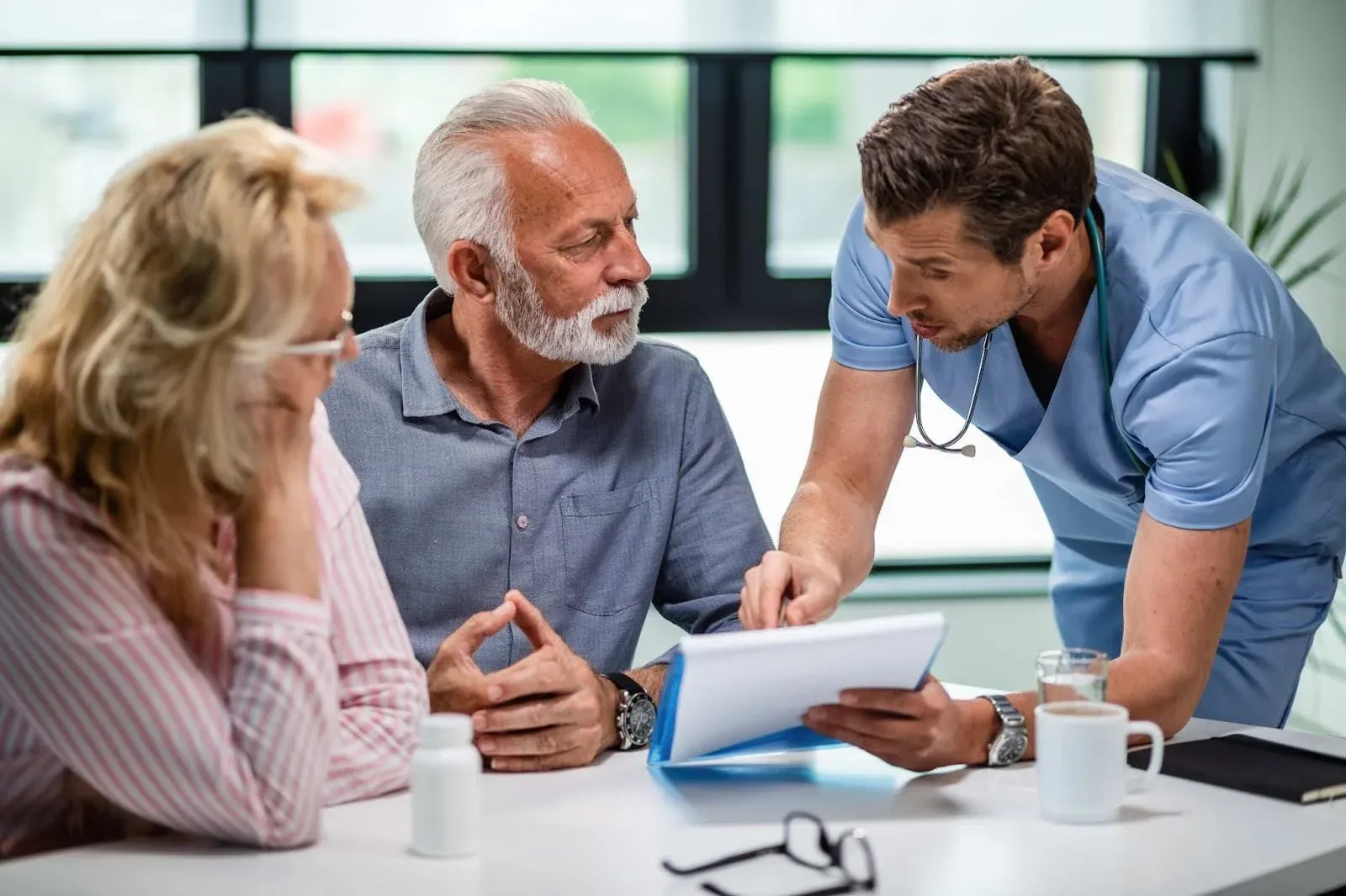doctor explaining something to an elderly couple.webp