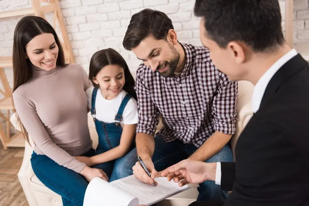 family signing a life insurance document.webp
