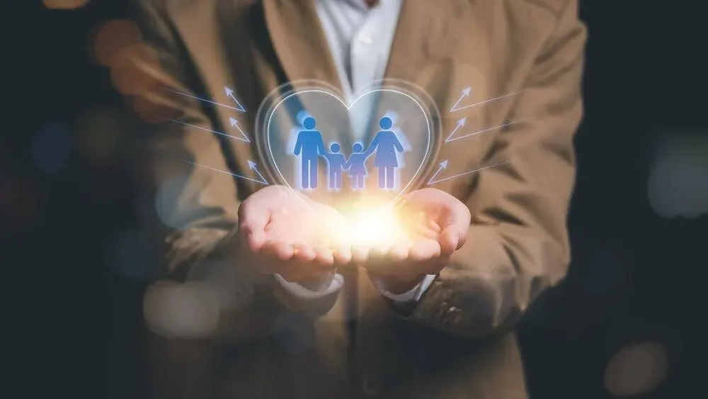 graphic image of a man holding a family icon in a heart shape.webp