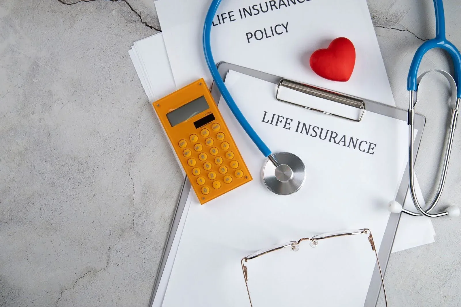 life insurance form with a stethoscope and calculator on top.webp
