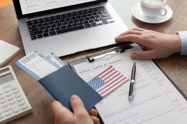 person with visa application form and tickets and passport in hand.webp