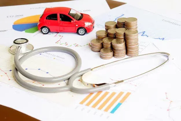 stethoscope, car and coins on top of a form.webp