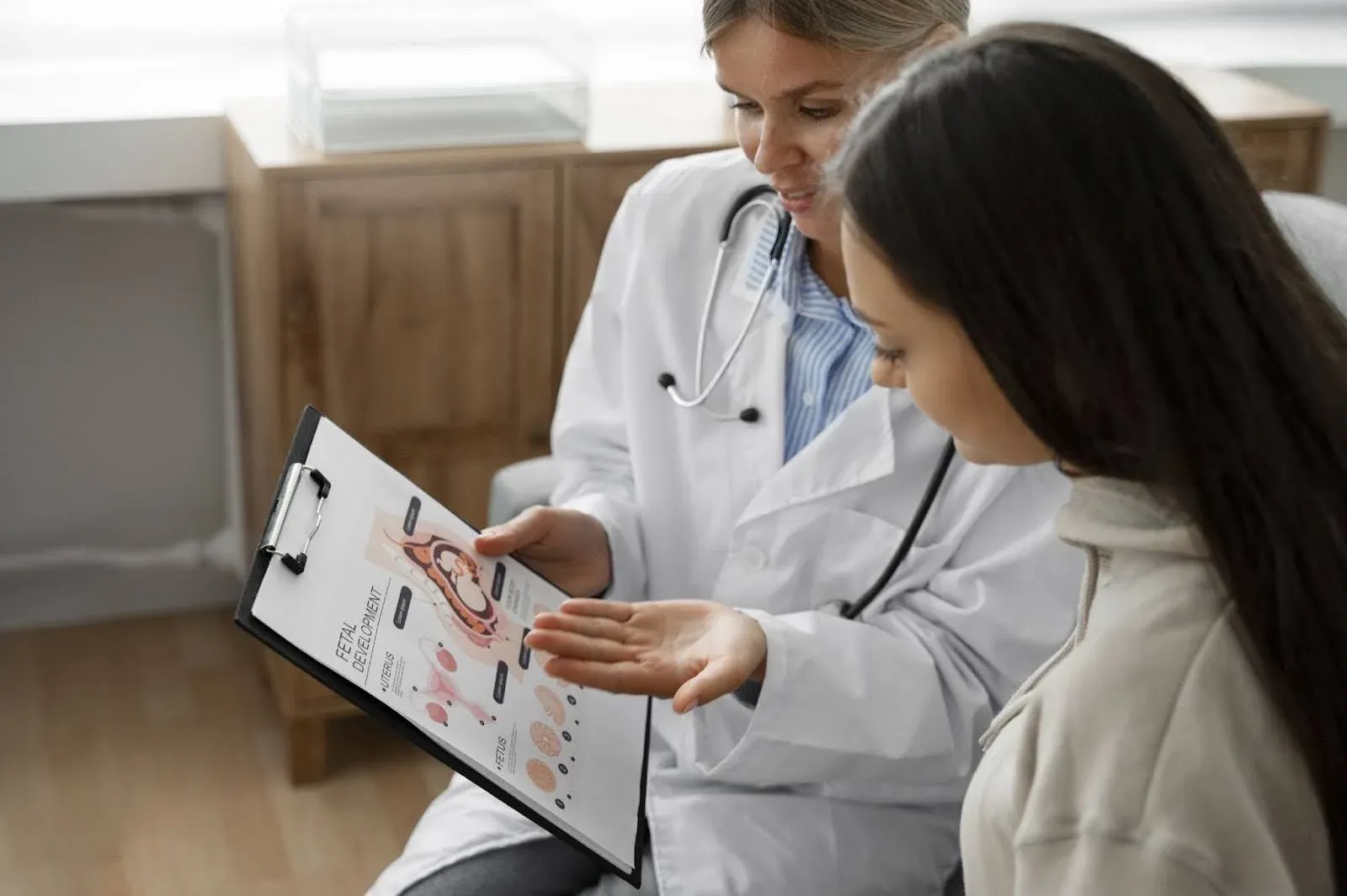 two doctors discussing something on a clipboard.webp