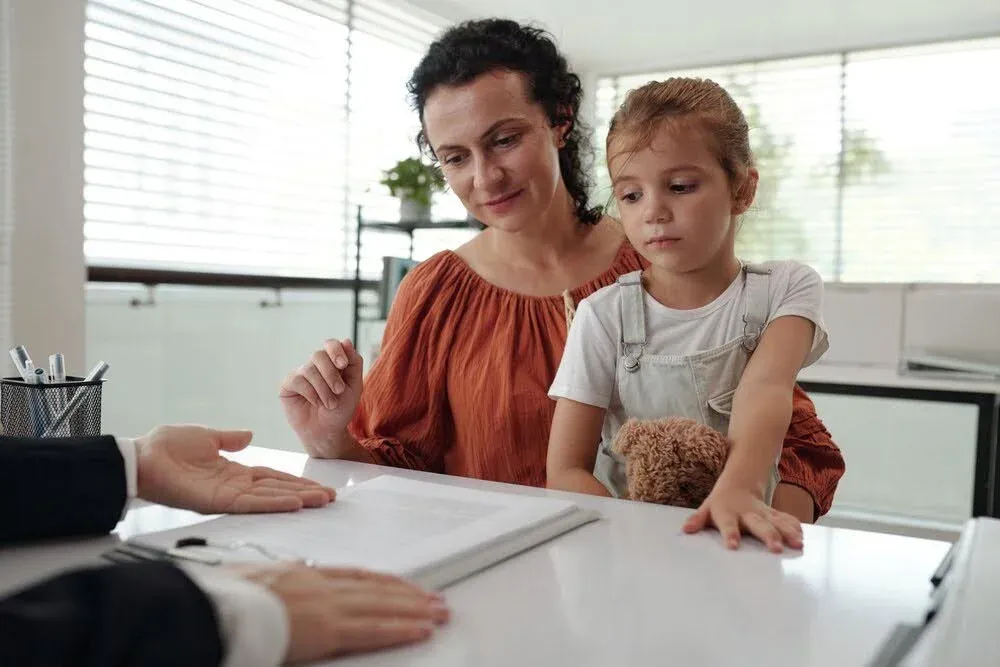 woman with her daughter signing some paperwork.webp